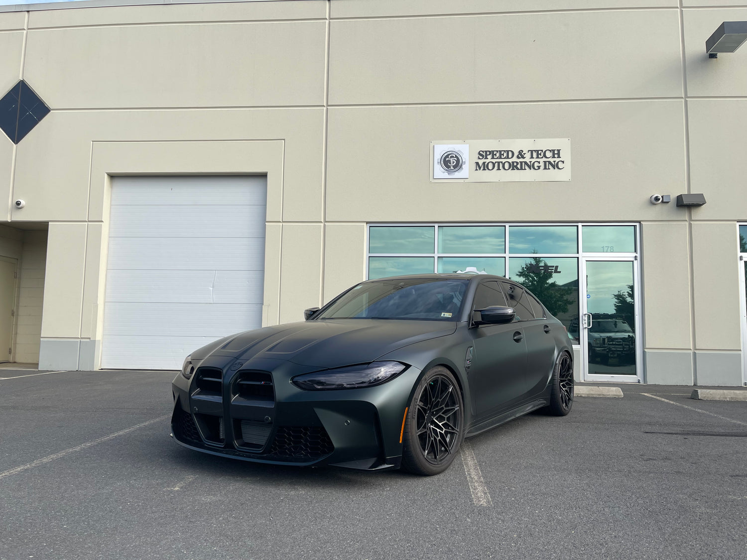 KPMF K75000 Series Premium Iridescent Wrapping Cast Vinyl Matte Platinum Dark Sage wrapped BMW car parked in front of a building with 'Speed & Tech Motoring Inc.' sign.