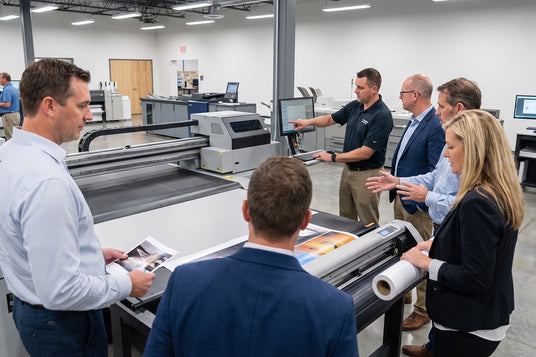 SignWarehouse technician leading hands-on in-house training at a printer and vinyl cutter