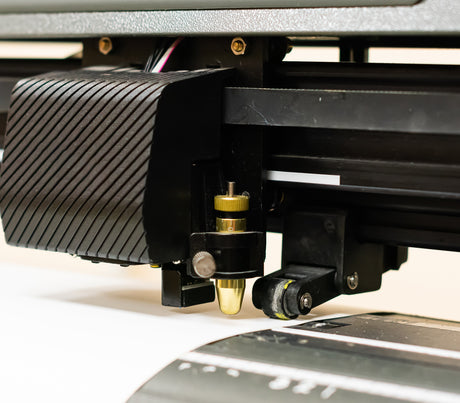 Closeup of vinyl cutter with blade and blade holder cutting