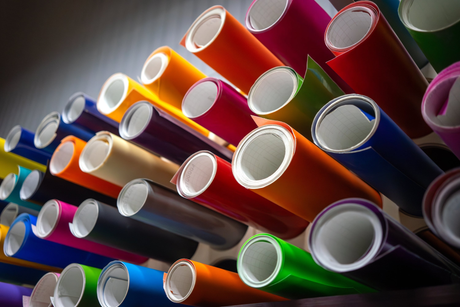 Rolls of colorful Oracal Vinyl displayed horizontally in a shelf