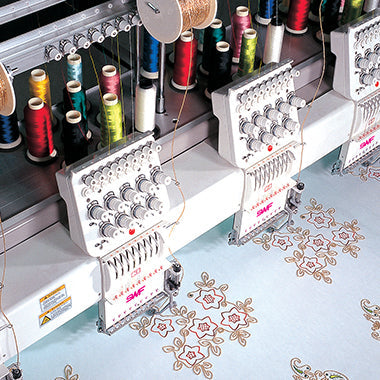 Embroidery Machine with various colorful rolls of thread on top.