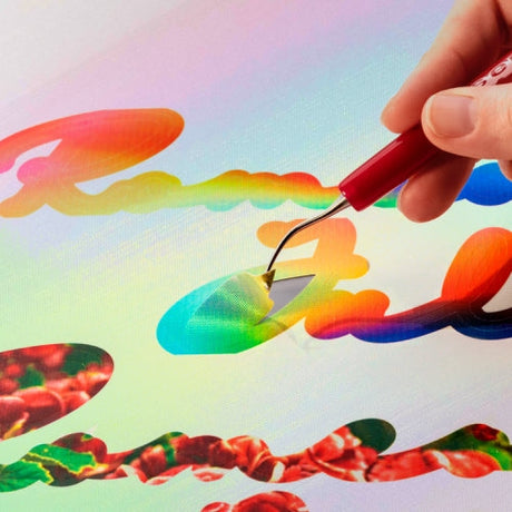Woman using weeding tool to carefully weed vinyl lettering 